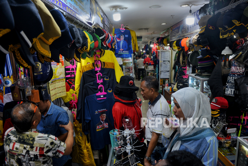 Calon pembeli memilah alat peraga kampanye berupa kaos dan asesoris partai politik di Pasar Senen, Jakarta, Selasa (24/10/2023). 