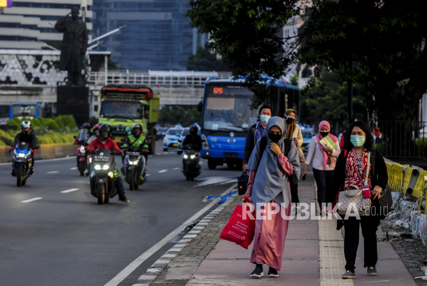Sejumlah karyawan swasta berjalan saat jam pulang kerja di Sudirman, Jakarta, Senin (8/6). Hasil survei terkait penanganan Covid-19 menyatakan mayoritas responden menyatakan mereka setuju PSBB berlanjut tetapi dengan kelonggaran.