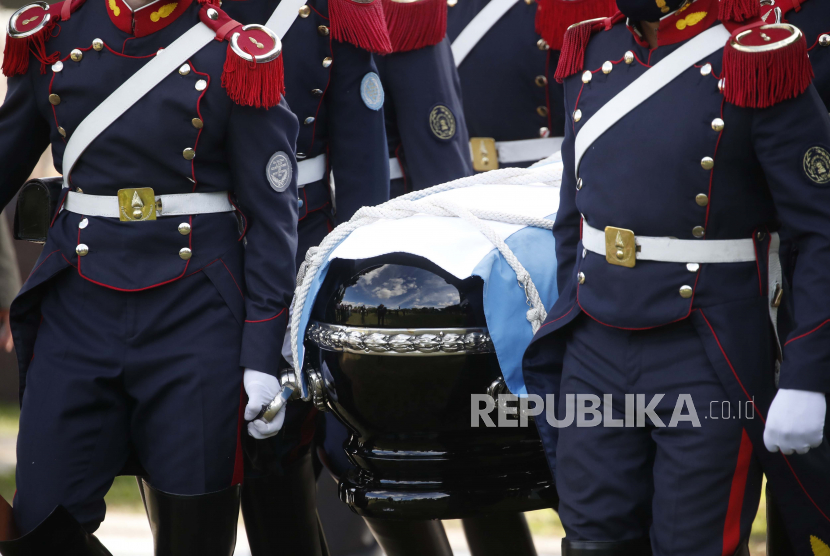 Peti mati mantan Presiden Argentina Carlos Menem yang dijatuhkan bendera dibawa selama upacara pemakamannya sebelum dimakamkan di Pemakaman Islam di San Justo, Argentina, Senin (15/2).