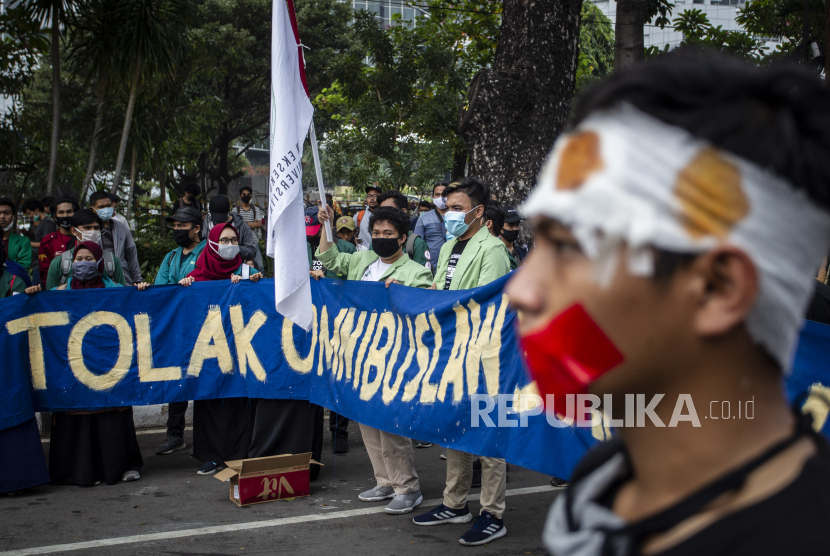Mahasiswa yang tergabung dalam Badan Eksekutif Mahasiswa Seluruh Indonesia (BEM SI) membentangkan spanduk saat menggelar unjuk rasa menolak Undang-Undang Cipta Kerja di kawasan Jalan Merdeka Barat, Jakarta, Jumat (16/10).
