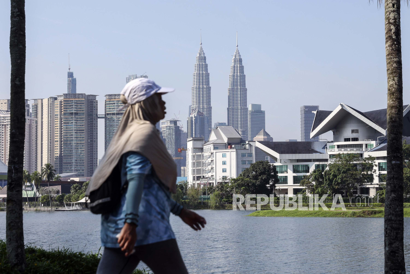 Pejalan kaki berjalan dengan latarbelakang  gedung-gedung bertingkat di Kuala Lumpur, Malaysia, Selasa (25/6/2024). Awal Ramadhan di Malasyai mulat Ahad (2/3/2025).