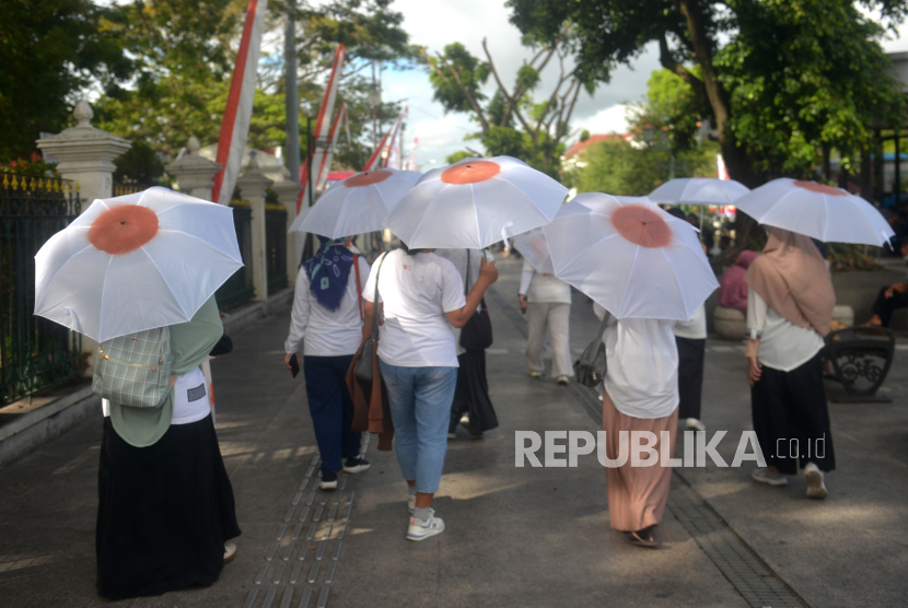 Ibu-ibu dari Asosiasi Ibu Menyusui Indonesia (AIMI) Bantul berjalan menggunakan payung putih berkampanye tentang pentingnya tahapan menyusui di kawasan Malioboro, Yogyakarta, Ahad (7/8/2022). AIMI menyerukan agar pemerintah memperbanyak konselor laktasi.