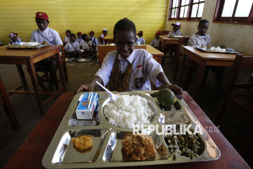 Pelajar menerima paket makanan Makan Bergizi Gratis di SD Santo Michael Bilogae, Distrik Sugapa, Kabupaten Sugapa, Intan Jaya, Papua Tengah, Senin (20/1/2025). Kementerian Pertahanan melalui Kogabwilhan III mendistribusikan paket makan bergizi gratis sebanyak 1000 paket makan diperuntukkan bagi sekolah-sekolah di salah satu daerah rawan konflik di Disktri Sugapa menggunakan helikopter serta diolah di dapur yang dikelola TNI. Program Makan Bergizi Gratis disebut sebagai langkah besar dalam sejarah kebijakan sosial Indonesia untuk mengatasi masalah malanutrisi, stunting, serta mendorong penguatan ekonomi lokal.   