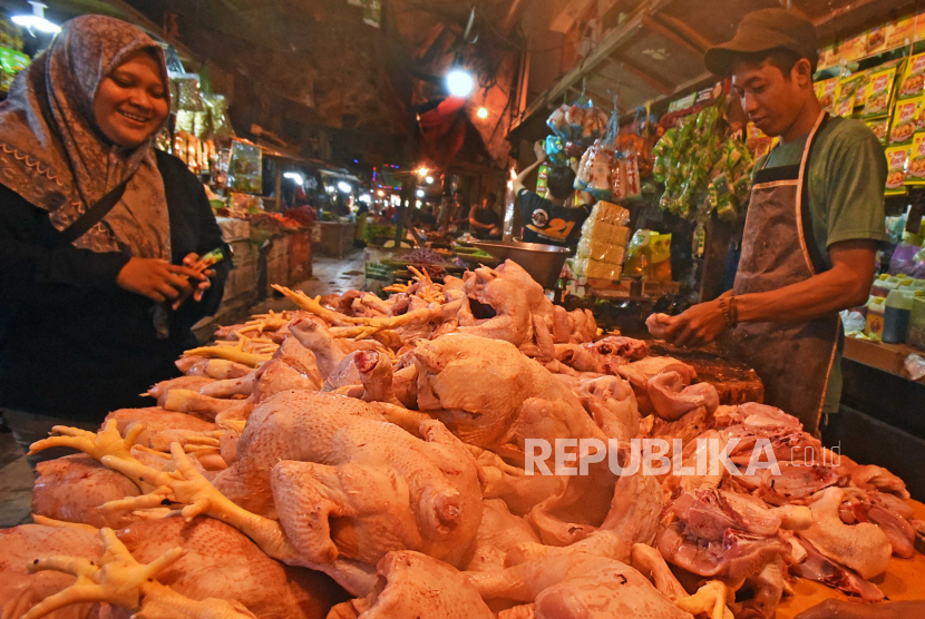 Pedagang daging ayam (kanan) melayani pembeli di pasar, Selasa (8/8/2023).
