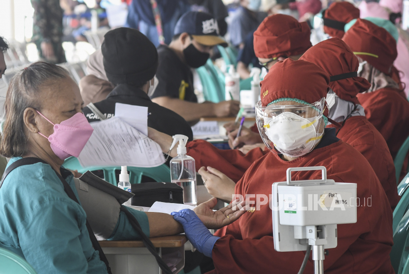 Petugas medis (kanan) mengukur tekanan darah warga yang akan mengikuti vaksinasi di Terminal Pulogebang, Jakarta Timur, Ahad (18/7/2021). Vaksinasi yang diadakan pada 17-18 Juli 2021 dengan target 10 ribu peserta diikuti warga, pegawai perusahaan otobus (PO) dan awak bus Antar Kota Antar Provinsi (AKAP). 