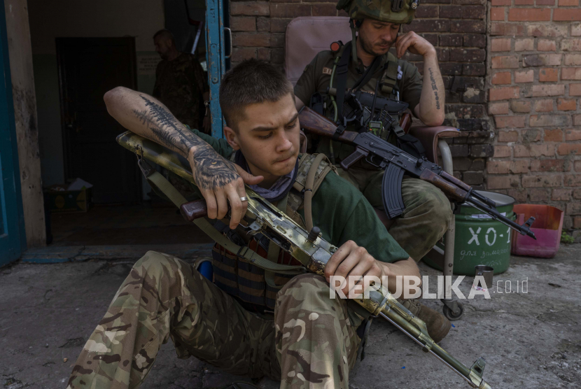  Seorang anggota keamanan tim penyelamat medis membersihkan senjatanya di wilayah oblast Donetsk, Ukraina timur, Sabtu, 4 Juni 2022. Pemerintah Rusia memperingatkan Barat agar tidak terus memasok persenjataan ke Ukraina.