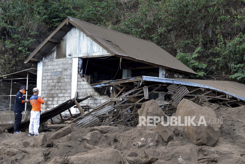 Tim penyelamat memeriksa sebuah rumah yang rusak akibat tanah longsor (ilustrasi).