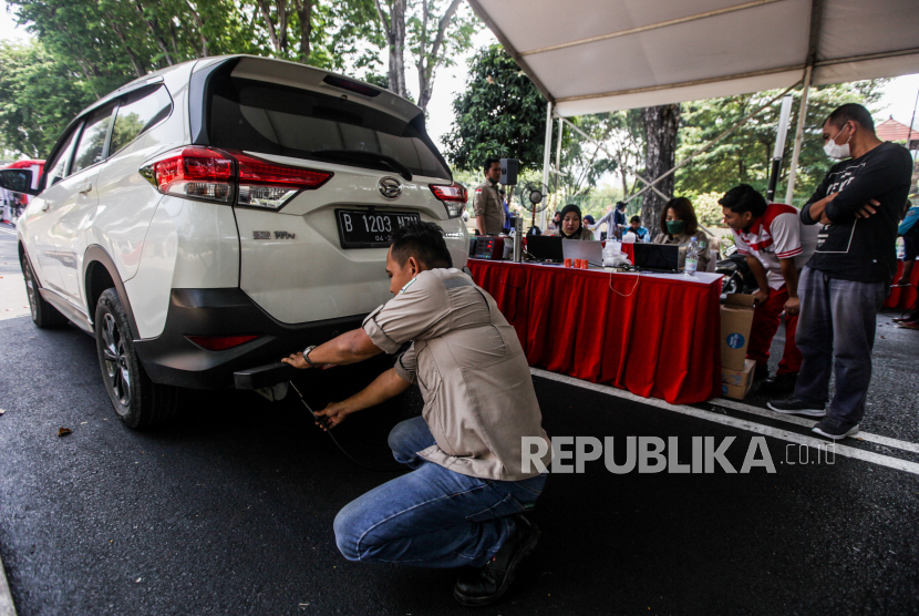 Petugas melakukan uji emisi kendaraan mobil di kawasan Gelora Bung Karno, Jakarta. Kadishub DKI mengeklaim telah koordinasi dengan Ditlantas Polda soal tilang uji emisi