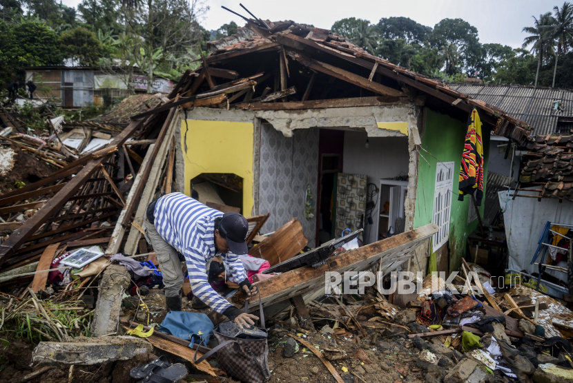 Warga menyelamatkan barang berharga dari rumah yang hancur akibat gempa dan longsor di kawasan Cijendil, Kecamatan Cugenang, Cianjur, Jawa Barat.