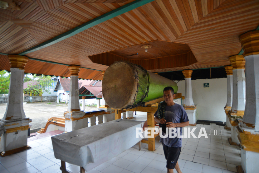 Warga melintasi beduk tua di dalam cagar budaya Masjid Raya Ampek Lingkuang, di Lubuk Alung, Padang Pariaman, Sumatera Barat, Sabtu (8/3/2025). Masjid iberatap limas ala masjid kuno Minangkabau yang dibangun pada tahun 1867 itu dinamakan Ampek Lingkuang karena terdapat empat kaum yang terlibat dalam pembangunannya, yakni kaum Balah Hilia, Singguliang, Sungai Abang, dan Koto Buruak. 