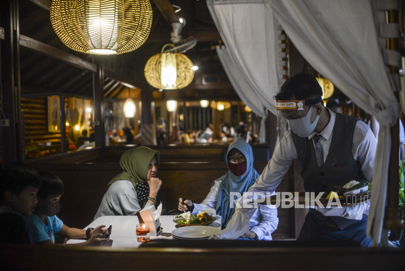 Pelayan menggunakan alat pelindung diri saat melayani pengunjung di Rumah Makan Bumi Aki, Pajajaran, Kota Bogor, Jawa Barat (ilustrasi). Kota Bogor, Jawa Barat mendapatkan hibah dana program pemulihan ekonomi nasional (PEN) dari Kementerian Pariwisata dan Ekonomi Kreatif sebesar Rp 73 miliar.