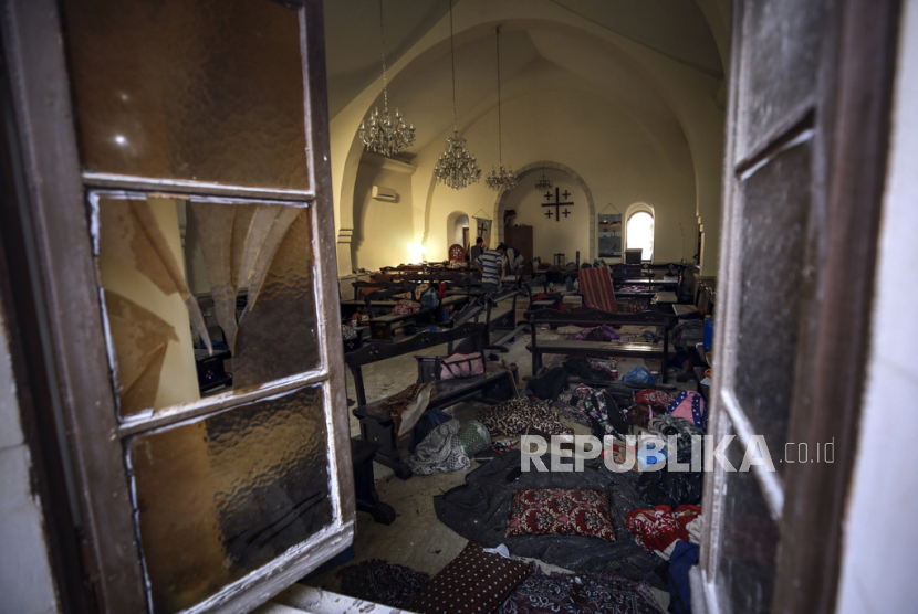 Warga Palestina memeriksa kerusakan di gereja yang digunakan warga sebagai tempat berlindung, di rumah sakit al-Ahli, di Kota Gaza, Rabu, (18/10/2023). 