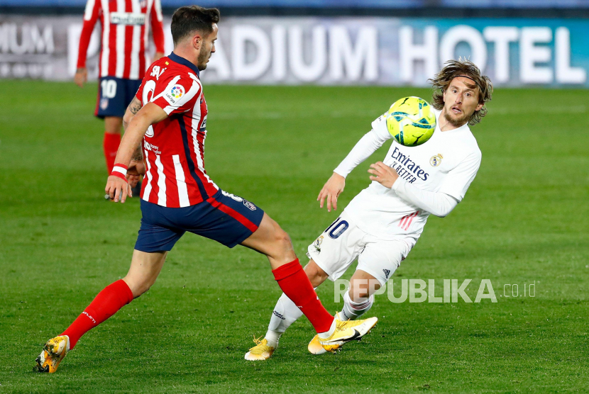 Gelandang Atletico Madrid Saul Niguez (kiri) berduel bola dengan playmaker Real Madrid Luka Modric. 