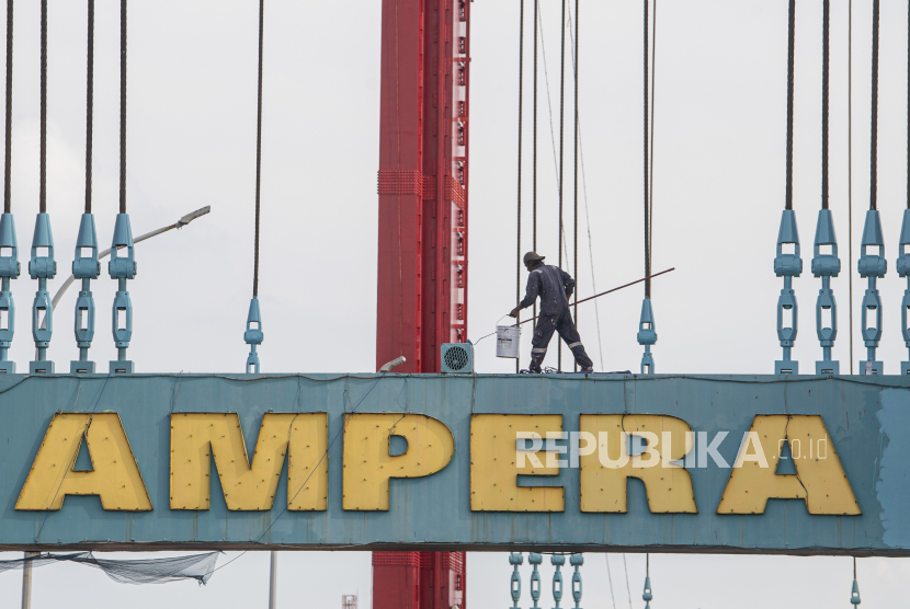 Pekerja melakukan pengecatan menara jembatan Ampera di Palembang, Sumatera Selatan, Kamis (3/11/2022). Balai Besar Pelaksana Jalan Nasional (BBPJN) Sumsel merevitalisasi jembatan Ampera yang meliputi perbaikan tiang penyangga yang mulai berkarat, penambahan kekuatan pada beton pondasi hingga pengecatan ulang jembatan yang menghubungkan kawasan Seberang Ulu dan Ilir Palembang.