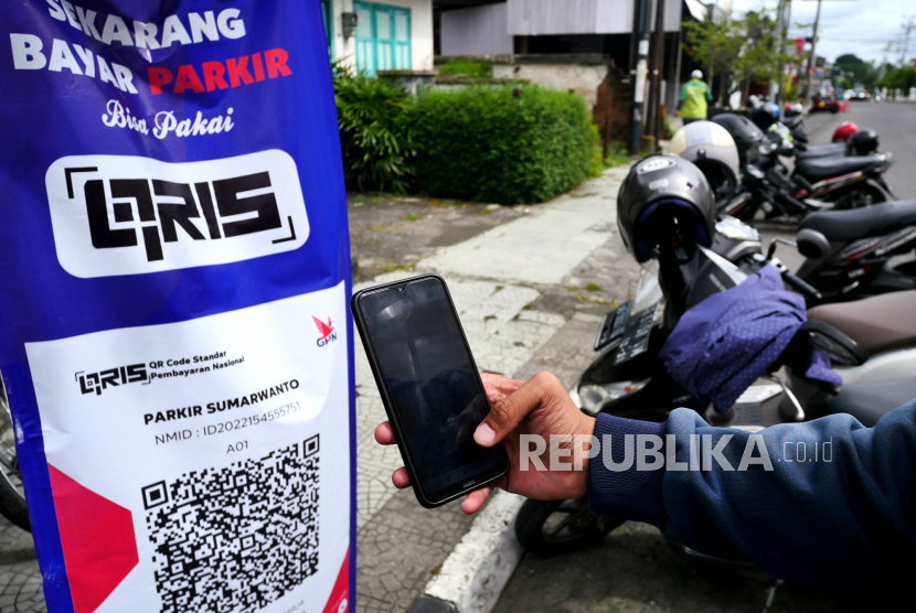 Warga membayar parkir secara nontunai di kawasan parkir Jalan Prof Yohannes, Yogyakarta, Senin (7/3/2022). Sejumlah pusat perbelanjaan di Kota Solo, Jawa Tengah, mulai menerapkan transaksi parkir secara digital. 