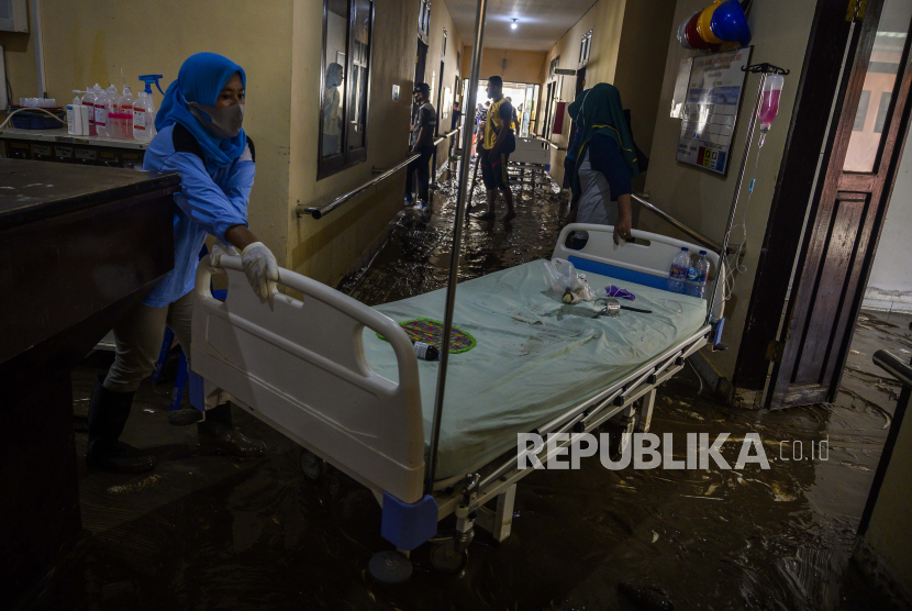 Petugas mengamankan barang-barang di dalam ruang perawatan yang digenangi lumpur di Rumah Sakit Umum Daerah (RSUD) Torabelo, Kabupaten Sigi, Sulawesi Tengah, Jumat (10/7/2020). Genangan lumpur yang disebabkan oleh luapan sungai di belakang rumah sakit tersebut terjadi pada Kamis (9/7/2020) petang akibat hujan deras dan mengakibatkan sebagian besar pasien meninggalkan rumah sakit kecuali yang diisolasi karena COVID-19. 