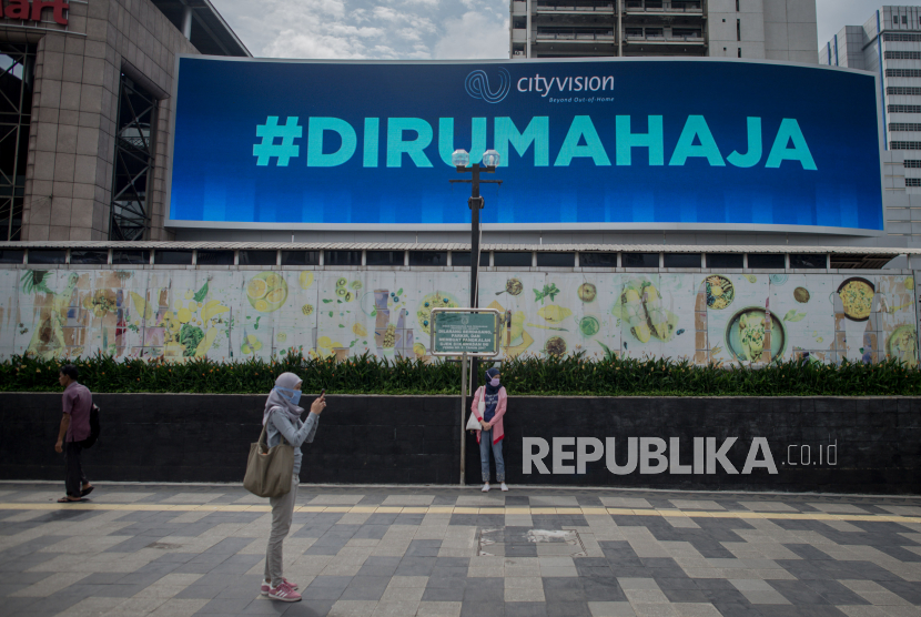 Papan reklame digital berisi imbauan dirumahaja terpasang di kawasan Sudirman, Jalan Jendral Sudirman, Jakarta, Rabu (8/4). Pemprov DKI Jakarta akan menerapkan kebijakan pembatasan sosial berskala besar (PSBB) di wilayah DKI Jakarta mulai tanggal 10 April 2020 mendatang