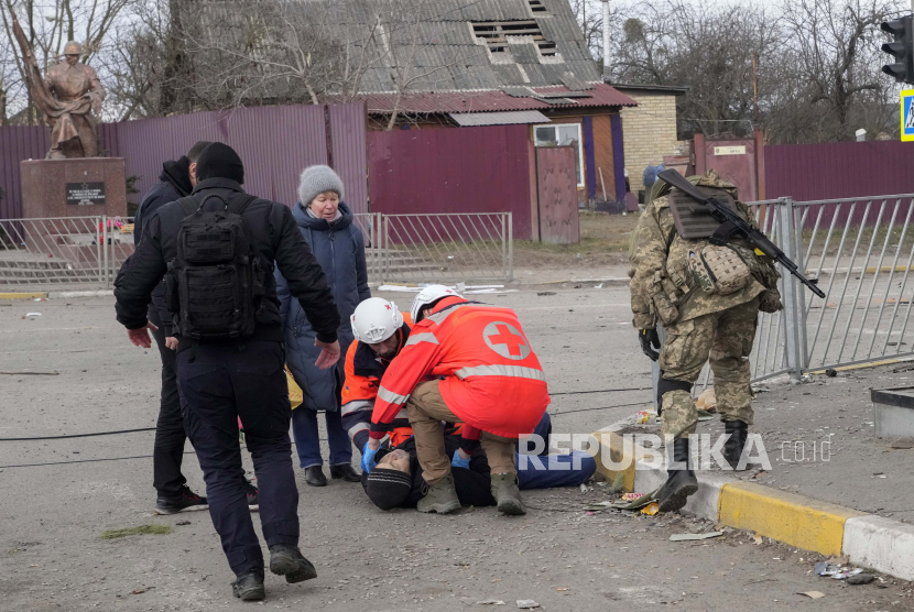 Paramedis merawat seorang pria tua yang kehilangan kesadaran setelah menyeberangi sungai Irpin saat melarikan diri dari kota Irpin dekat Kyiv, Ukraina, Senin, 7 Maret 2022. Rusia 