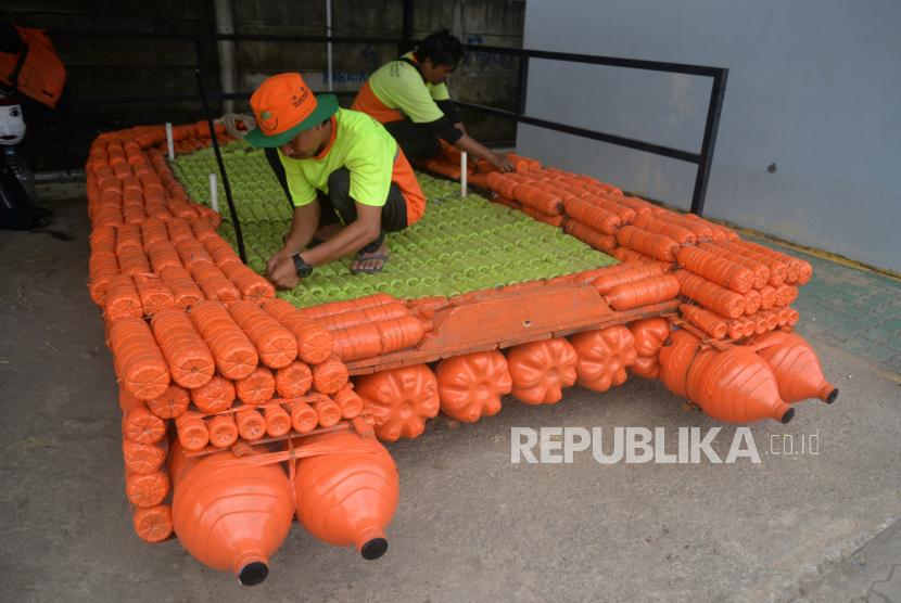 Petugas Unit Penanganan Sampah (UPS) Badan Air Kecamatan Jatinegara menyelesaikan pembuatan perahu berbahan botol plastik bekas di Jakarta, Kamis (16/5/2024). Menurut petugas UPS Badan Air, Perahu tersebut dibuat dengan memanfaatkan 70 galon plastik, 400 botol plastik ukuran besar dan 300 botol plastik ukuran kecil. Perahu yang memiliki ukuran panjang 4 m dan lebar 2,5 m dan bisa membawa enam orang tersebut saat ini dalan tahap finishing.