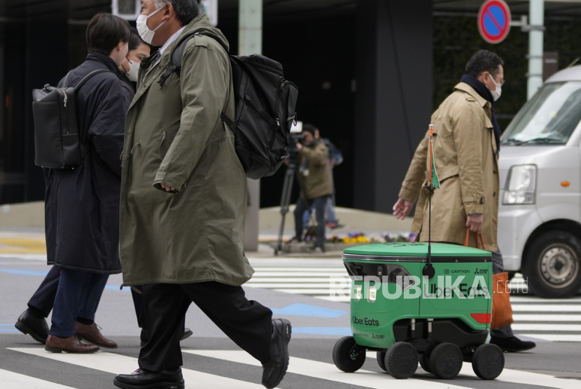 Robot pengantar makanan Uber Eats menerobos pejalan kaki saat demonstrasi untuk media di Tokyo, Jepang, Selasa, (5/3/2024).
