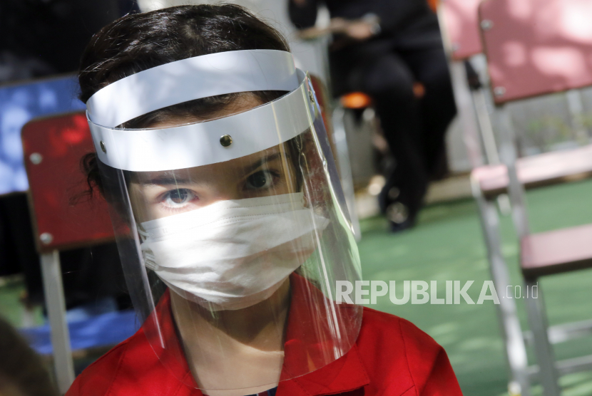  Seorang gadis Iran etary sekolah mengenakan masker wajah menghadiri hari pertama pembukaan kembali sekolah swasta Bamdad Parsi, utara Teheran, Iran, 05 September 2020. Iran diproyeksikan berada dalam gelombang ketiga dari wabah virus corona tipe baru atau Covid-19.