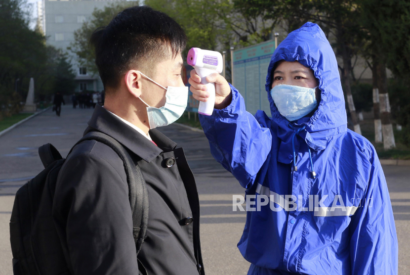 Seorang siswa diperiksa suhu tubuhnya sebagai tindakan pencegahan terhadap virus corona di Universitas Teknologi Kim Chaek, Pyongyang, Rabu (22/4). Menurut Pemerintah Korea Utara, usaha Korea Utara memerangi COVID-19 berhasil, karena sejauh ini tidak sama sekali mencatat adanya kasus corona