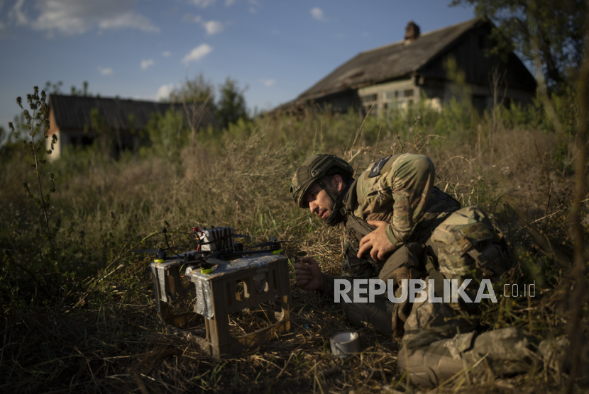 Seorang tentara Ukraina berjuluk Stem memeriksa drone yang sebelum lepas landas membawa bahan peledak di garis depan di pinggiran Kremmina, Ukraina, beberapa waktulalu.