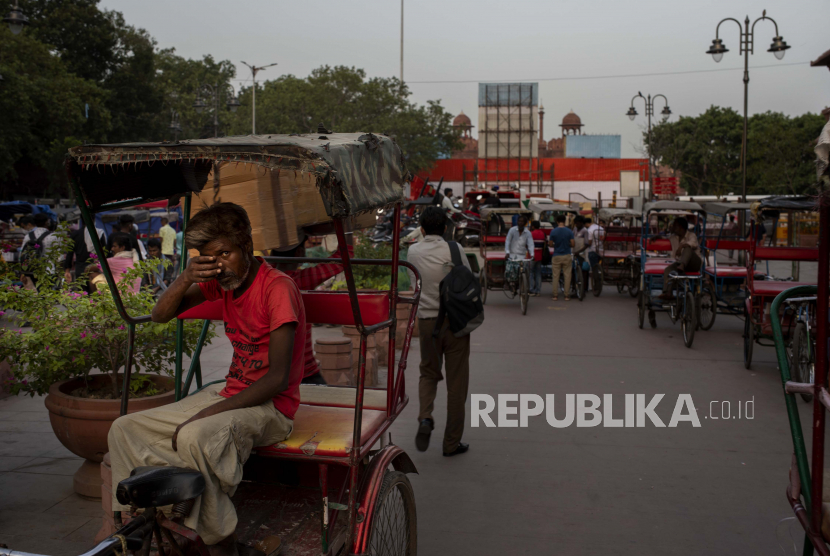 Seorang penarik becak menunggu penumpang saat peti kemas ditempatkan di jalan utama yang menghalangi pemandangan Benteng Merah, di New Delhi, India, Selasa, 10 Agustus 2021.