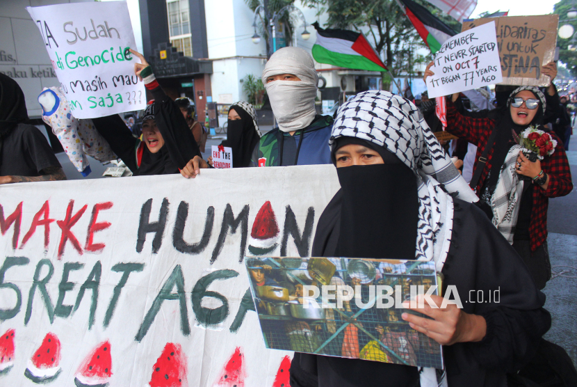 Massa yang tegabung dalam Solidaritas Seni untuk Palestina menggelar aksi memperingati dua tahun tragedi kemanusiaan di Gaza, di Palestina Walk, Jalan Asia Afrika, Kota Bandung, Selasa (7/10/2025). Aksi tersebut menyerukan agar masyarakat memboikot produk yang terafiliasi dengan Israel dan hentikan genosida kepada warga Palestina.