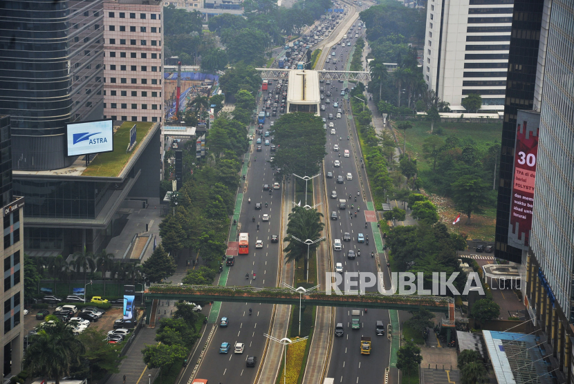 Kendaraan melintas di antara gedung bertingkat di Jakarta, Senin (14/10/2024).