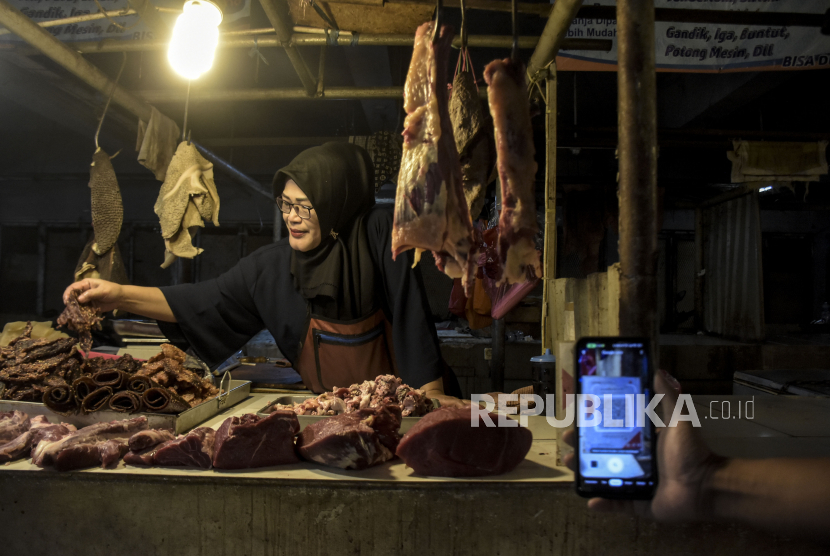 Warga melakukan transaksi digital menggunakan QRIS (Quick Response Code Indonesian Standard) saat membeli daging di Pasar Kosambi, Kota Bandung, Jawa Barat, Senin (10/7/2023). Bank Indonesia memberlakukan biaya layanan QRIS bagi Penyedia Jasa Pembayaran (PJP) sebesar 0,3 persen dari yang sebelumnya sebesar 0 persen atau gratis. Dalam aturan yang berlaku sejak 1 Juli tersebut, pedagang tidak boleh membebankan balik ke konsumen atau pembeli.