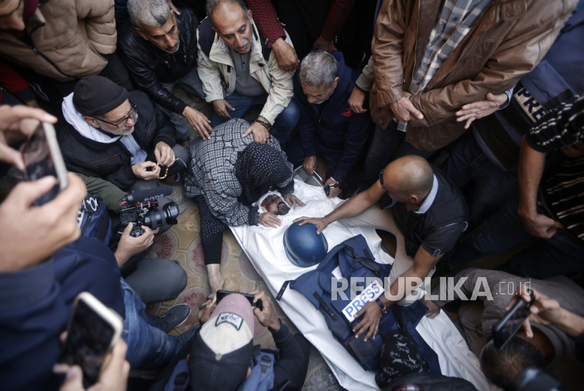 Kerabat kameramen Al Jazeera, Samer Abu Daqqa  berduka atas jenazahnya yang gugur akibat serangan udara Israel saat pemakamannya di kota Khan Younis, Jalur Gaza selatan. Sabtu, (16/12/2023).