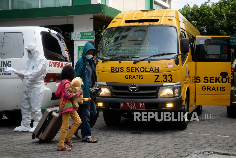 Pasien COVID-19 berjalan menuju bus Sekolah yang akan membawa mereka menuju Rumah Sakit Darurat Wisma Atlet di Puskesmas Kecamatan Menteng, Jakarta, Ahad (20/6). Laju kasus harian Covid-19 di Indonesia beberapa hari terakhir dalam tren menanjak, Hal ini membuat angka 2 juta kasus infeksi Covid-19 di Indonesia berada di depan mata.Prayogi/Republika. 