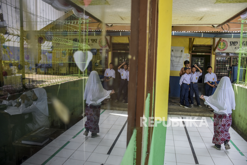 Sejumlah siswa beraktivitas di depan ruang kelas SMP PGRI 6 yang berdampingan dengan ruang kelas SDN 205 Neglasari di Jalan Sadang Sari, Coblong, Kota Bandung, Kamis (11/8/2022). Sebanyak 34 siswa beserta guru dan staf di SMP tersebut terpaksa mengikuti kegiatan belajar mengajar dengan menumpang ruangan sempit milik SDN 205 Neglasari Kota Bandung, akibat tidak adanya bangunan sekolah sendiri serta fasilitas sarana dan prasarana sekolah yang kurang layak. Republika/Abdan Syakura
