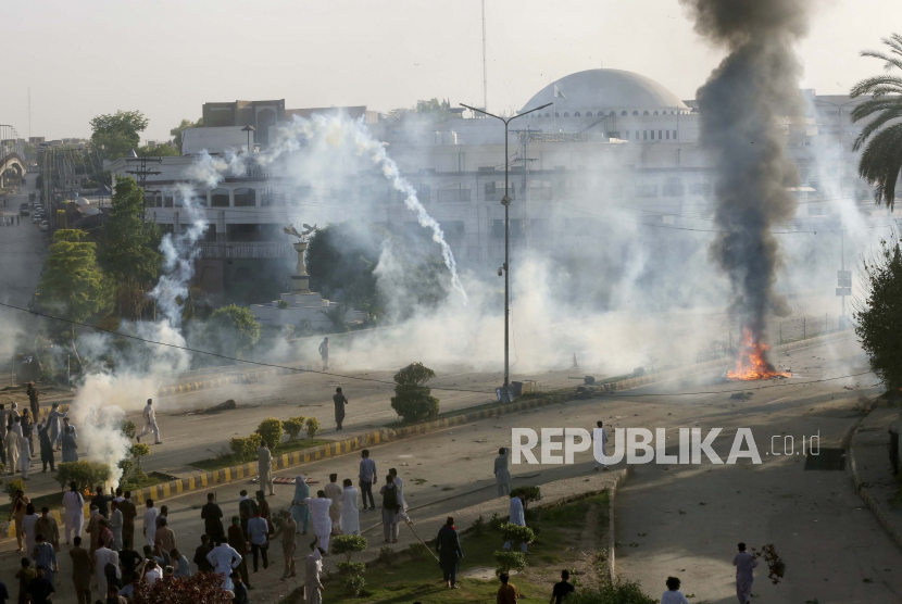 Polisi menembakkan gas air mata untuk membubarkan pendukung mantan perdana menteri Imran Khan di Peshawar, Selasa (9/5/2023). Mereka memprotes penahanan  Khan oleh lembaga antikorupsi Pakistan. 