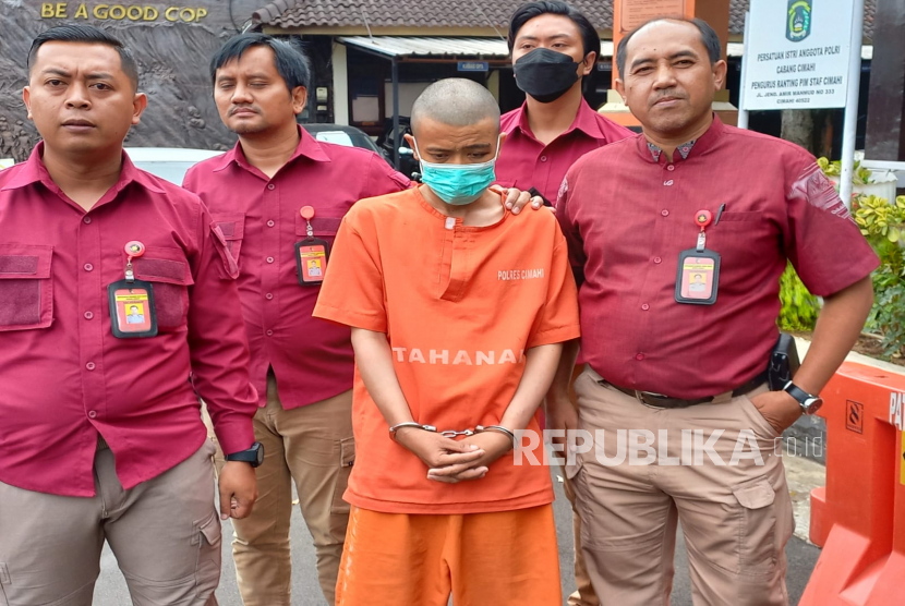 Petugas Satreskrim Polres Cimahi tengah membawa Ade Bogel (37 tahun) pelaku penganiayaan terhadap anak kandung hingga tewas di sebuah kontrakan di Jalan Pesantren, Kota Cimahi di Mapolres Cimahi, Rabu (8/2/2023). 
