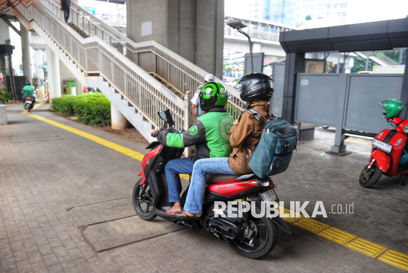 Pengemudi ojek online melintas di Trotoar Kawasan Pancoran, Jakarta, Selasa (24/6/2025). Kemenhub menegaskan, rencana penyesuaian tarif ojek online (ojol) sebesar 8-15 persen masih dalam tahap kajian.