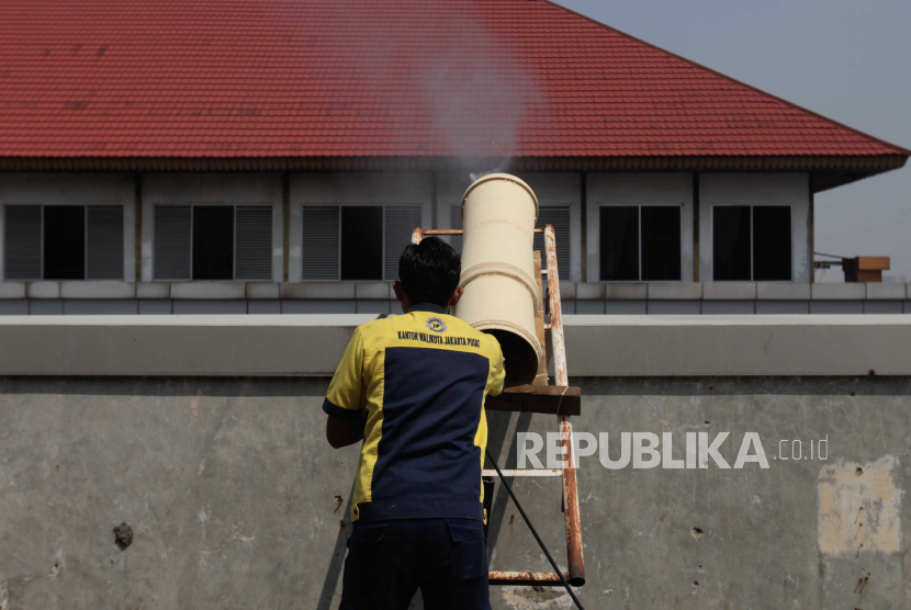 Petugas menyemprotkan air ke udara di Kantor Wali Kota Jakarta Pusat.