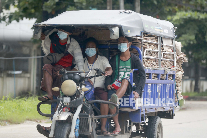 Orang-orang yang memakai masker untuk membantu mengekang penyebaran virus corona mengendarai sepeda roda tiga untuk mengangkut barang di kota Shwe Pyi Thar di Yangon, Myanmar, Rabu, 28 Juli 2021.