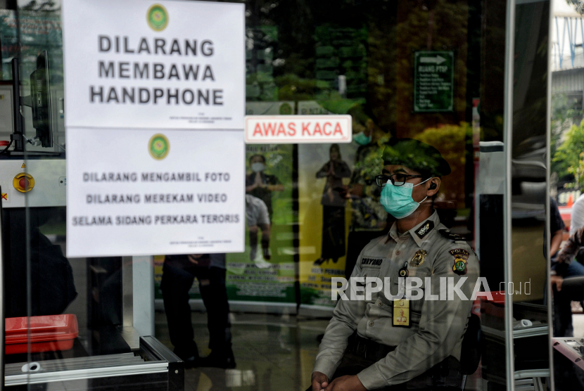 Petugas Kepolisian berjaga di depan pintu masuk ruangan persidangan terdakwa kasus dugaan tindak pidana teroris Munarman di Pengadilan Negeri Jakarta Timur. Pada hari ini Munarman dituntut 8 tahun penjara oleh jaksa penuntut umum. (ilustrasi)