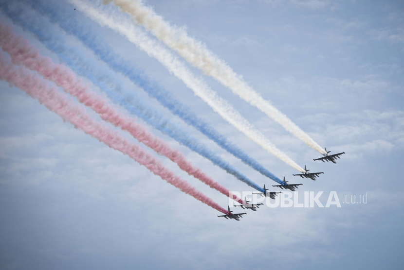 Pesawat tempur Rusia terbang di atas Lapangan Merah meninggalkan jejak asap dalam warna bendera nasional selama gladi bersih untuk parade militer Hari Kemenangan di Moskow, Rusia, Sabtu, 7 Mei 2022. 
