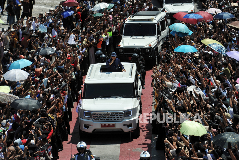 Presiden Prabowo Subianto menyapa warga saat iring-iringan mobil presiden melintas di Bundaran Hotel Indonesia, Jakarta, Ahad (20/10/2024).  Setelah dilantik di Gedung MPR RI, presiden dan wakil presiden periode 2024-2029 Prabowo dan Gibran disambut warga di sepanjang jalan Sudirman- Thamrin menuju Istana Negara untuk menghadiri acara gelar pelepasan presiden Joko Widodo dan penyambutan presiden baru.