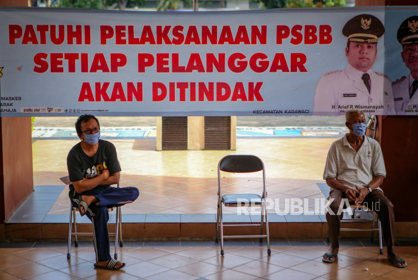 Warga menunggu giliran pemeriksaan cepat COVID-19 (Rapid Test)  bagi pelanggar pembatasan sosial berskala besar (PSBB) di Kantor Kecamatan Karawaci, Kota Tangerang, Banten, Kamis (14/5/2020). 