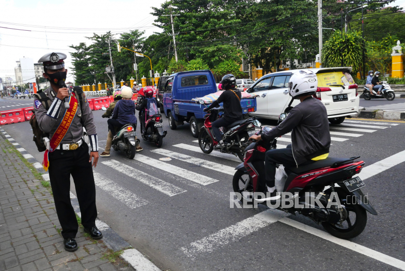 Petugas melakukan imbauan kepada pengendara tentang PPKM Darurat bertanya kepada saat penyekatan di Jalan Adisucipto, Yogyakarta, Rabu (7/7). Penyekatan dilakukan untuk proses penyemprotan disinfektan oleh petugas. Penyemprotan ini untuk mengurangi  penyebaran Covid-19.