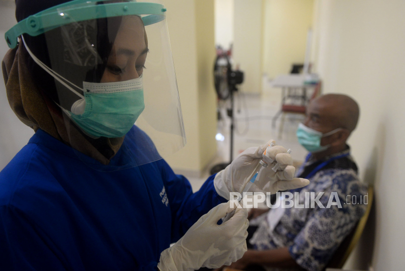 Vaksinator mempersiapkan vaksin COVID-19 sebelum diberikan kepada warga lansia di GOR Pancoran, Jakarta, Selasa (23/3). Pemerintah mengakui vaksinasi lansia berjalan lambat.
