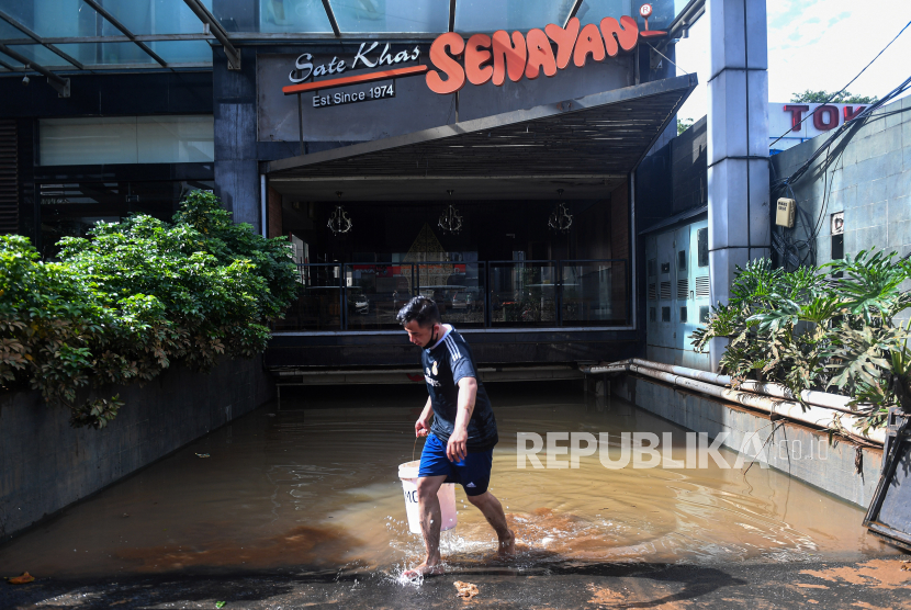 Warga mengambil air dari tempat makan yang terdampak banjir di kawasan Kemang, Jakarta Selatan, Minggu (21/2/2021). Banjir yang melanda permukiman warga di kawasan tersebut sudah berangsur surut dan warga mulai membersihkan lumpur sisa banjir. 