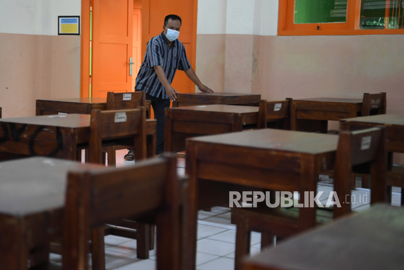 Pekerja menata bangku di ruang kelas sekolah di SMA Negeri 87, Jakarta, Selasa (24/8/2021). Pemerintah Provinsi DKI Jakarta belum menggelar pembelajaran tatap muka dan masih melakukan kajian untuk penerapannya meski status PPKM di Jakarta telah turun di level 3.