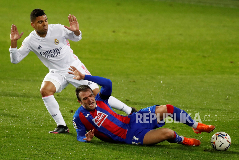 Striker Eibar Kike Garcia (kanan) bersaing memperebutkan bola dengan gelandang Real Madrid Casemiro (kiri) pada Liga Spanyol antara SD Eibar dan Real Madrid yang diadakan di Stadion Ipurua di Eibar, Spanyol,  Ahad (20/12/2020).