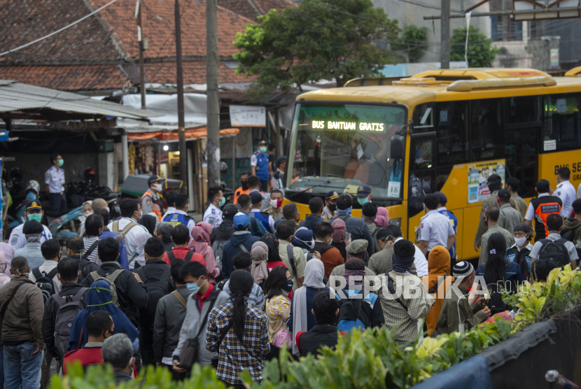 Sejumlah warga mengantre masuk ke dalam bus yang disediakan pemerintah untuk antisipasi membludaknya calon pemnumpang Kereta Rel Listrik (KRL) Commuterline di Stasiun KA Kota Bogor, Jawa Barat, Senin (29/6/2020). Memakai masker di tengah cuaca terik terkadang bisa mendatangkan sedikit ketidaknyamanan.