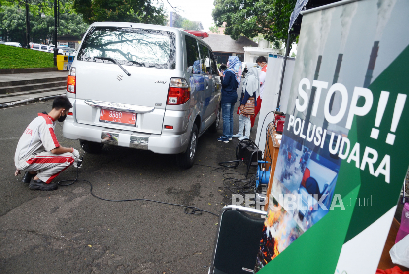 Ilustrasi. Petugas melakukan uji emisi gas buang mobil.